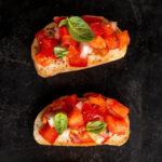 A serving of Classic Bruschetta, with vibrant tomatoes and fresh basil on toasted bread, symbolizing Italy's simple yet flavorful approach to cuisine.