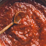 A pan of simmering homemade tomato sauce from scratch, demonstrating the simplicity and authenticity of Italian cooking.