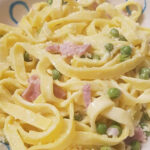 A delicious serving of Fettuccine Panna with Prosciutto Cotto and Peas, a renowned Italian dish.
